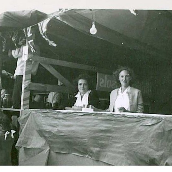 Two volunteers at an evening fair booth